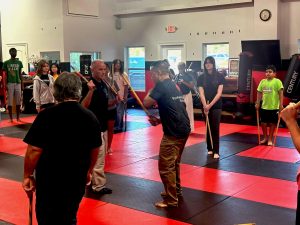 Group of students practicing the martial art Kali with 2 sticks